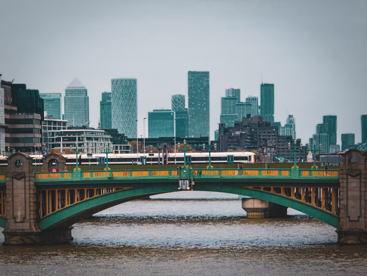 Southwark Bridge spanning the Thames with London's modern skyline in the background.