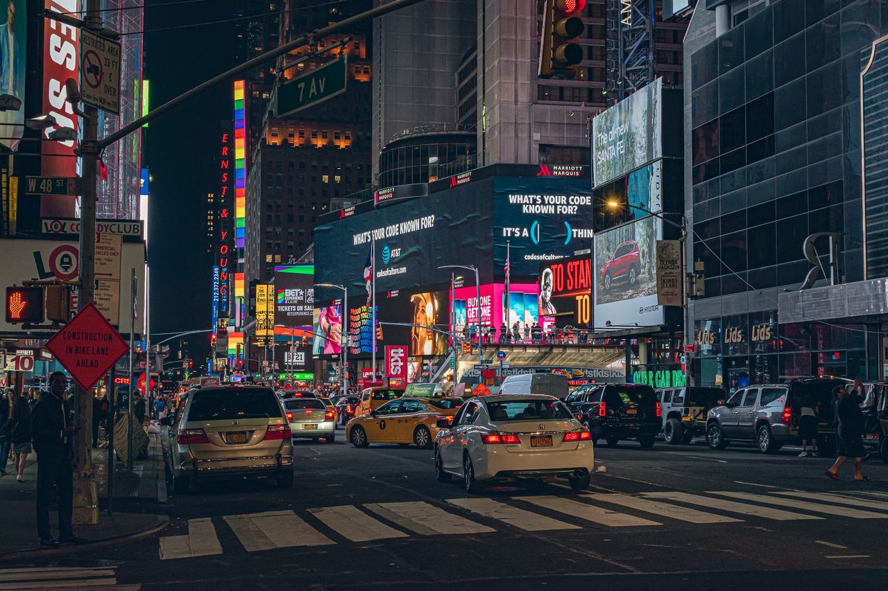 Bustling Times Square at night with vibrant billboards and traffic showcasing New York City's energy.